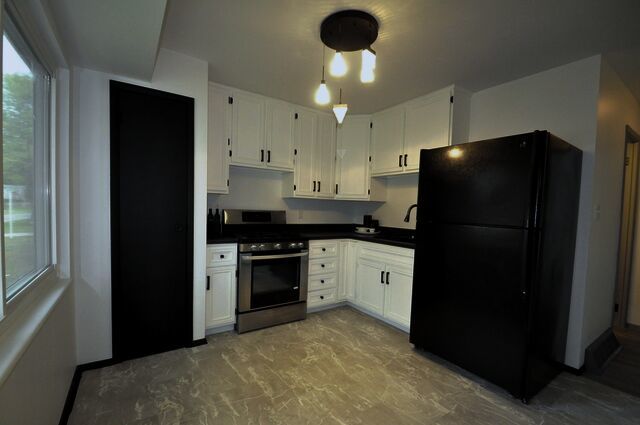 1703 Florence Street Streator, IL 61364 - Photo 7 of 33 a kitchen with a refrigerator and a stove top oven