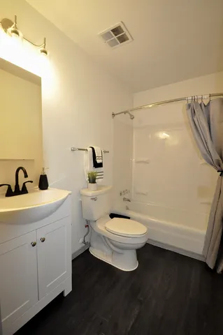 a bathroom with a toilet a sink a mirror and bathtub