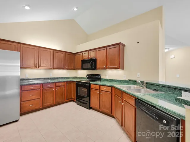 a kitchen with stainless steel appliances granite countertop a sink and cabinets