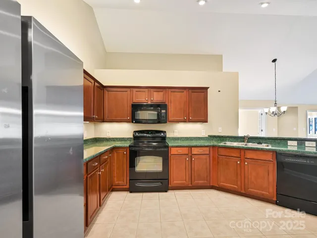a kitchen with stainless steel appliances granite countertop a sink and a stove top oven