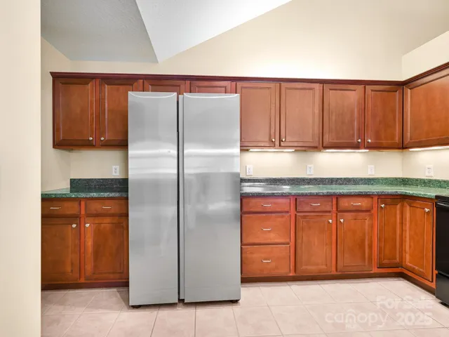 a kitchen with stainless steel appliances granite countertop a refrigerator and a sink