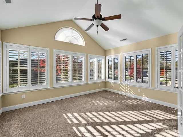a view of an empty room with a window and a ceiling fan