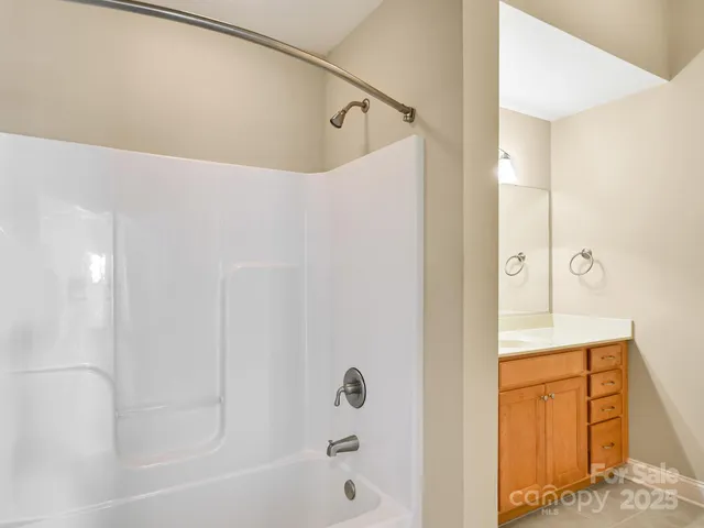 a bathroom with a tub shower sink and vanity