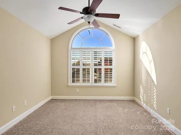 an empty room with a window and a ceiling fan