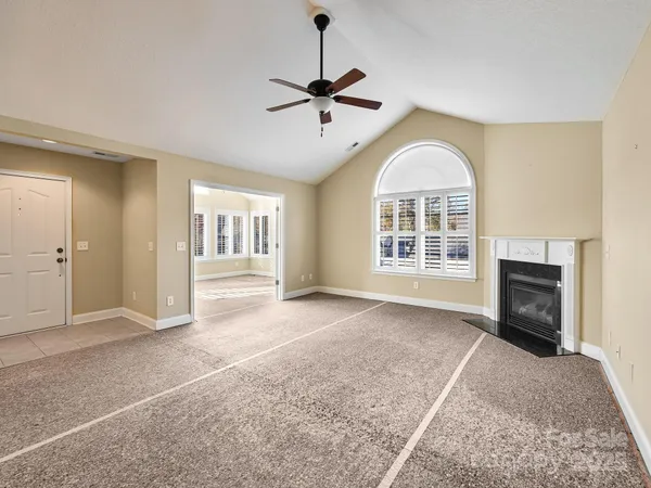a view of an empty room with a fireplace and a window