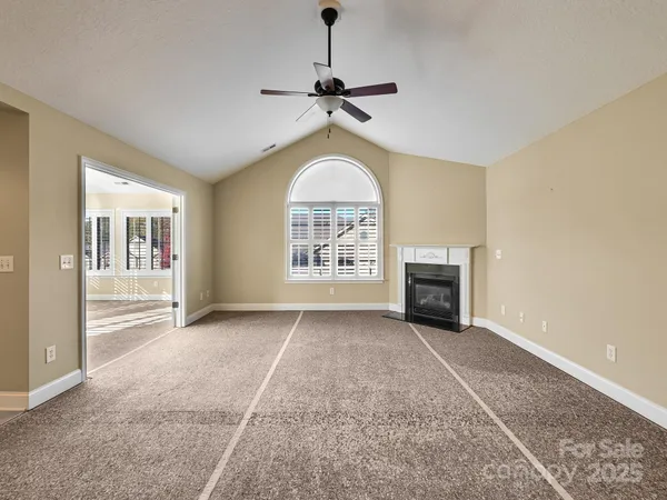a view of an empty room with a fireplace and a window