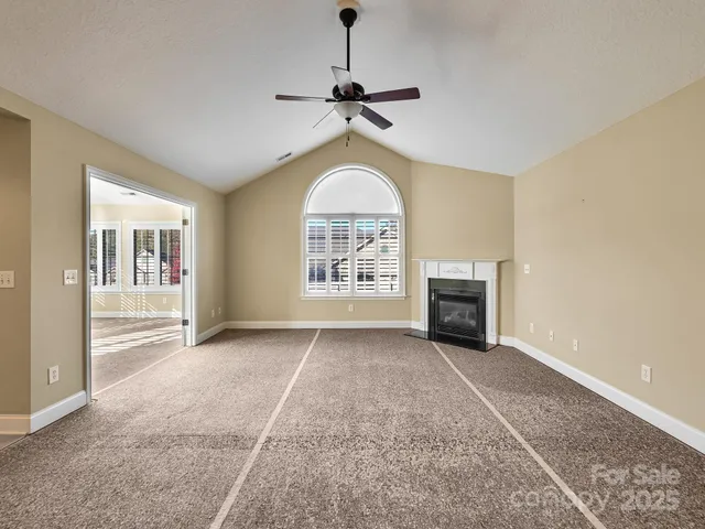 a view of an empty room with a fireplace and a window