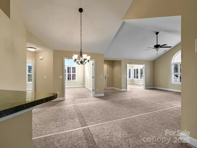 a view of a livingroom with a chandelier fan and windows