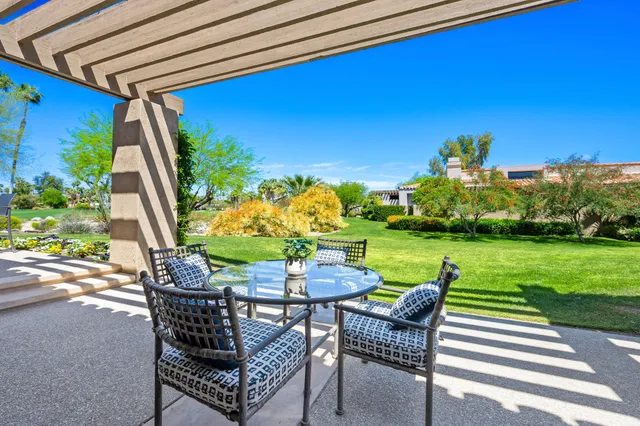 a view of a chairs and table in patio with a yard