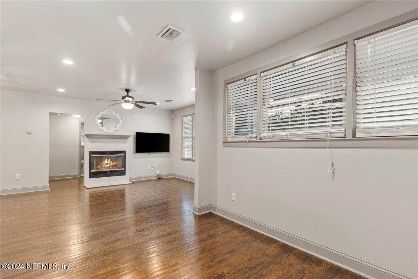 1273 Lechlade Circle Jacksonville, FL 32205 - Photo 11 of 33 an empty room with wooden floor fireplace and windows
