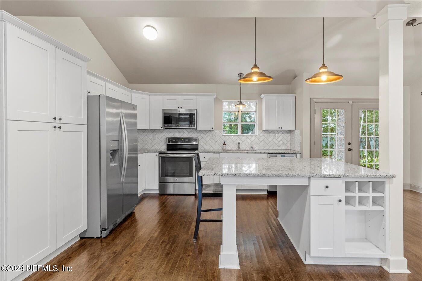1273 Lechlade Circle Jacksonville, FL 32205 - Photo 13 of 33 a kitchen with stainless steel appliances granite countertop a refrigerator a stove a microwave oven a sink with island and chairs