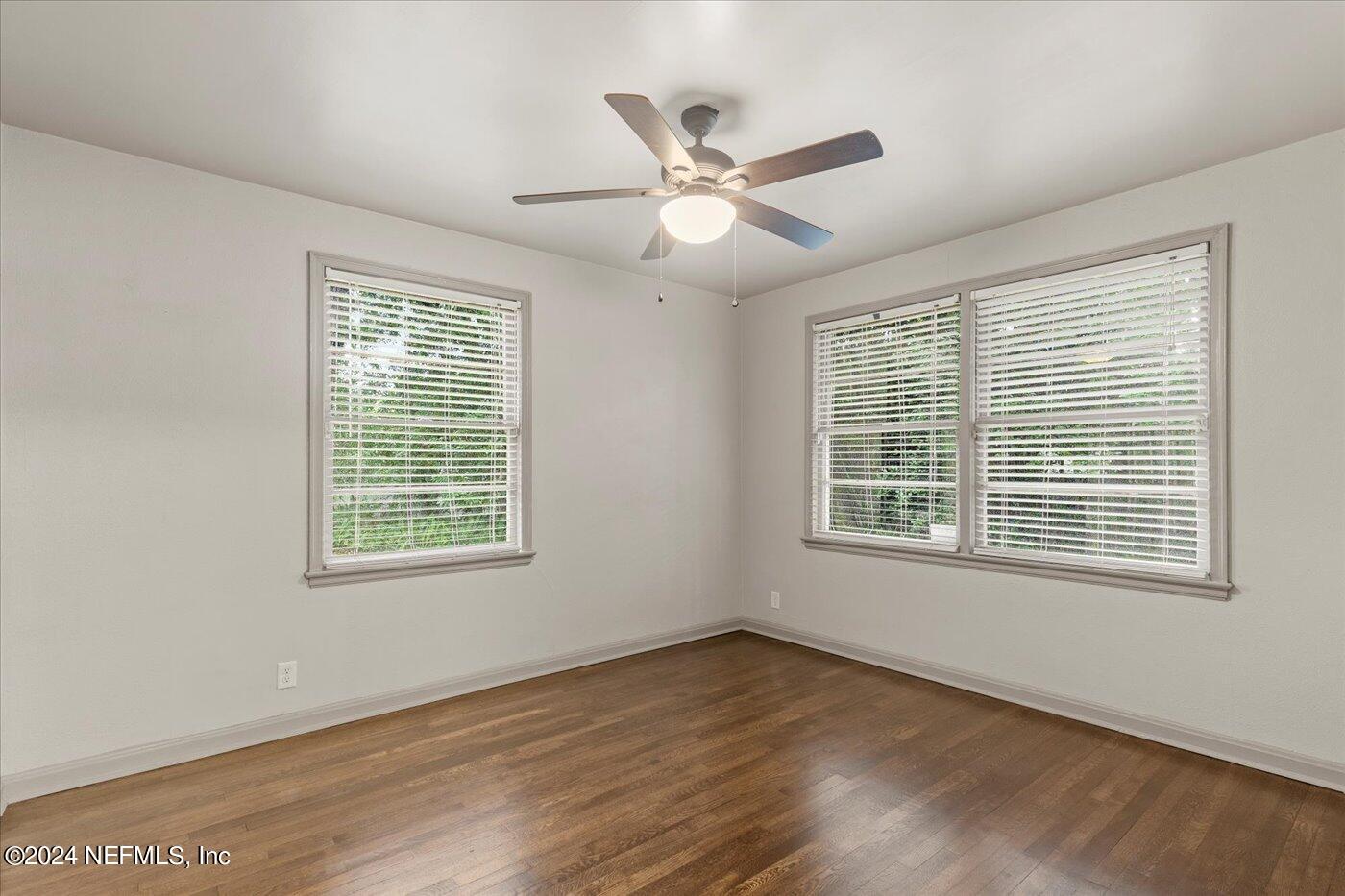 1273 Lechlade Circle Jacksonville, FL 32205 - Photo 22 of 33 an empty room with wooden floor windows and fan
