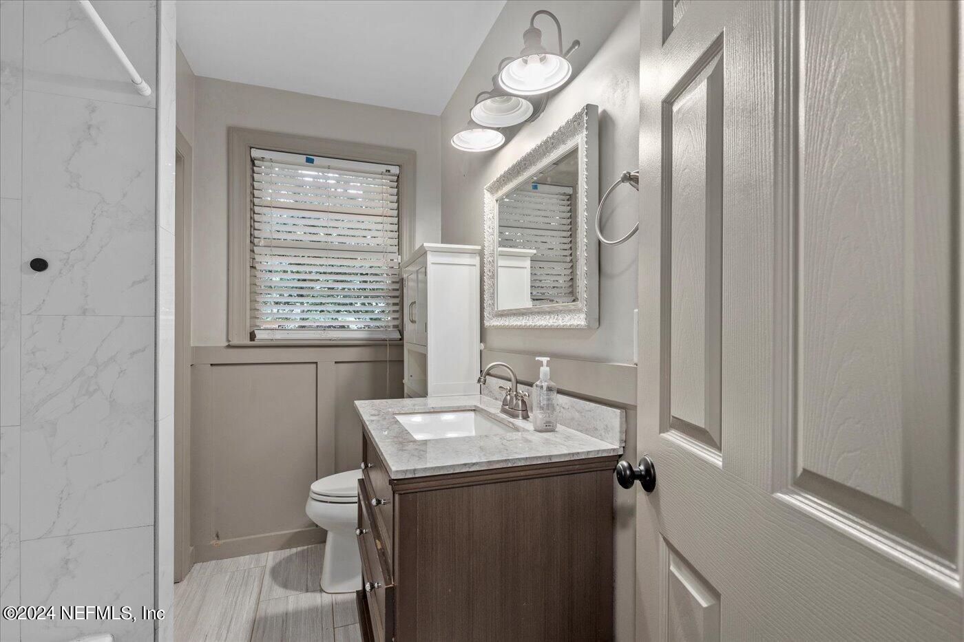 1273 Lechlade Circle Jacksonville, FL 32205 - Photo 24 of 33 a bathroom with a sink a toilet and a mirror