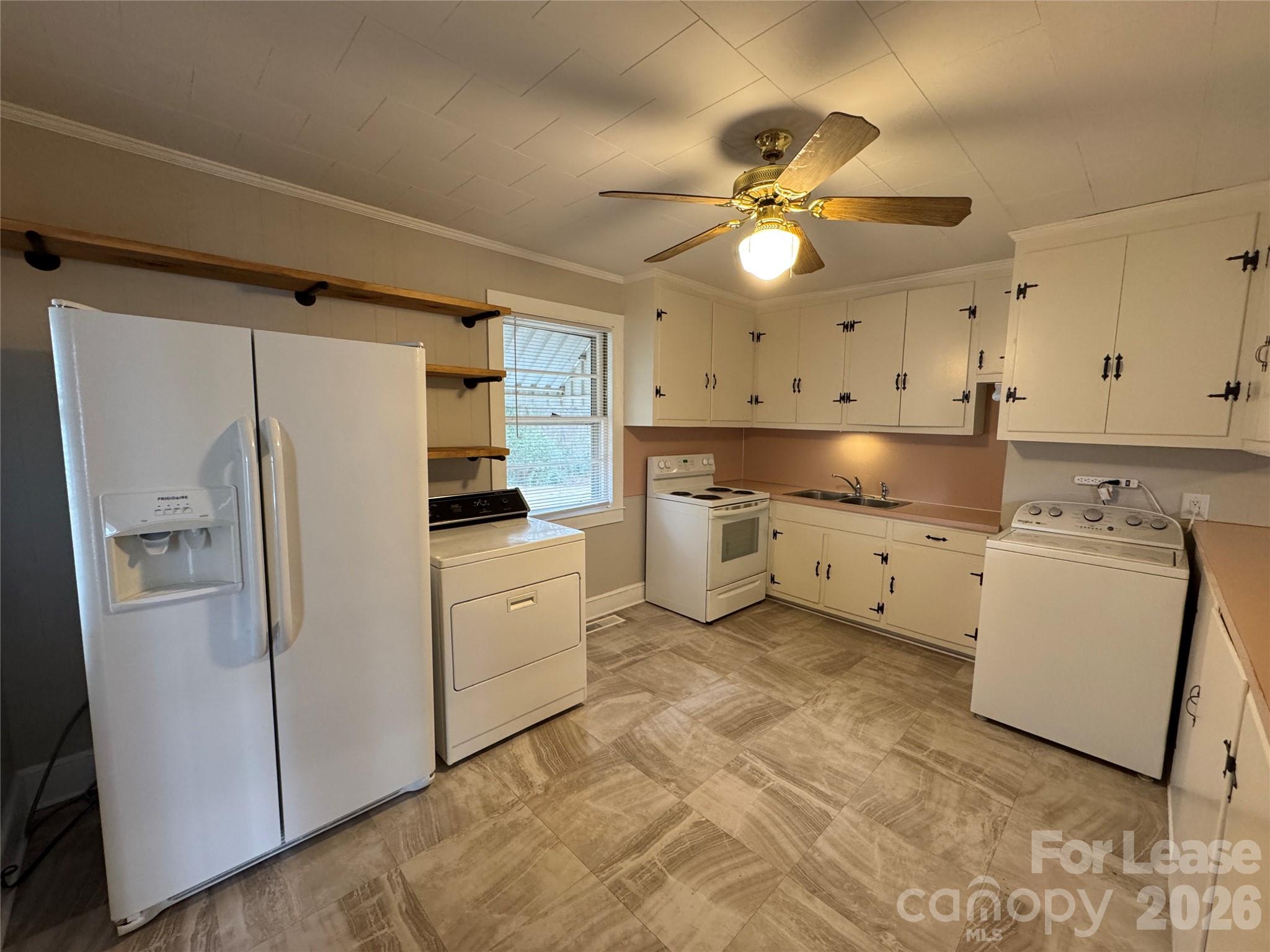 9019 Reames Road Charlotte, NC 28216 - Photo 4 of 7 a kitchen with white cabinets and white appliances
