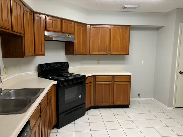 a kitchen with a sink dishwasher stove and cabinets