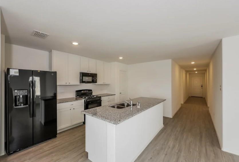 10225 Hackberry Spg Way Crowley, TX 76036 - Photo 4 of 11 Kitchen featuring black appliances, recessed lighting, white cabinetry, and light wood-type flooring