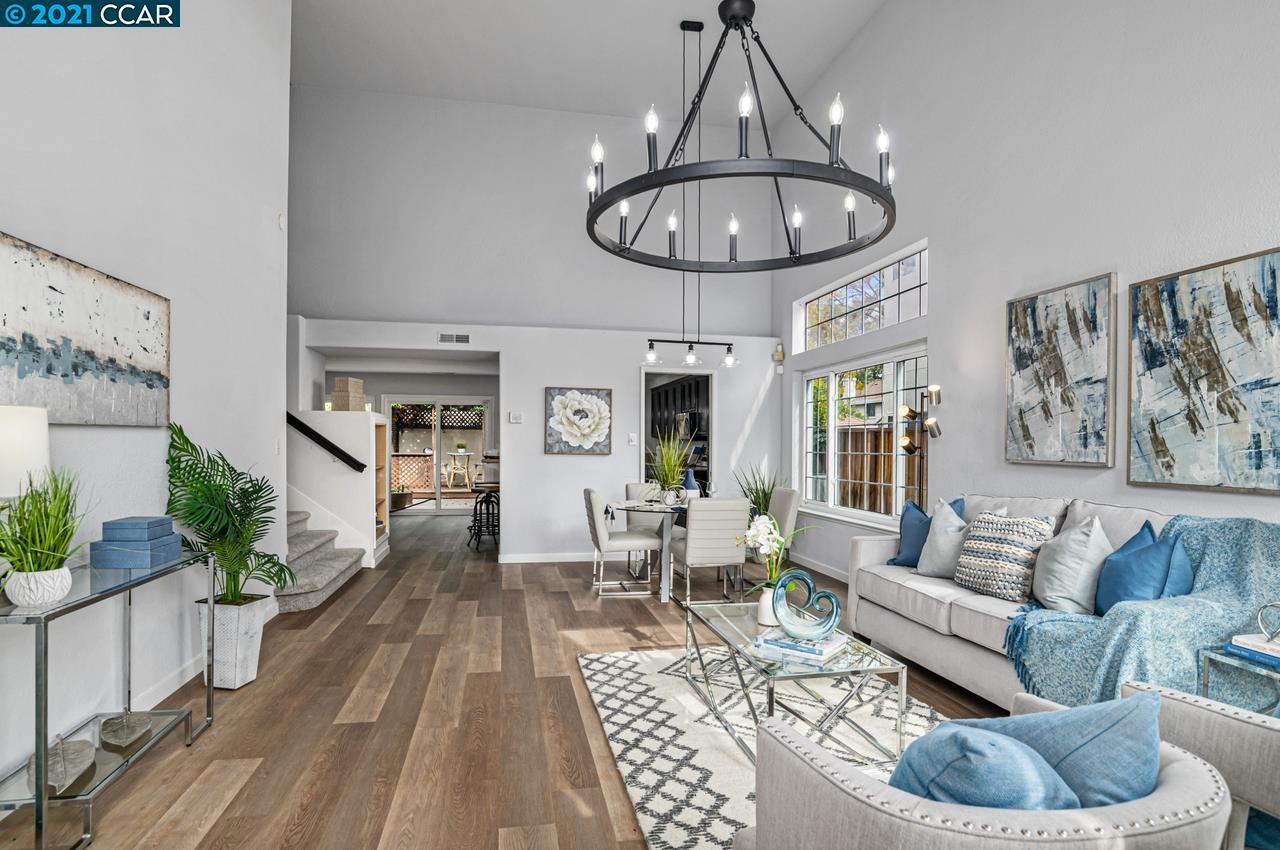 a living room with furniture a dining table and a chandelier