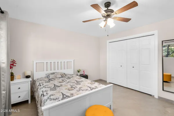 a bedroom with a bed and a chandelier fan