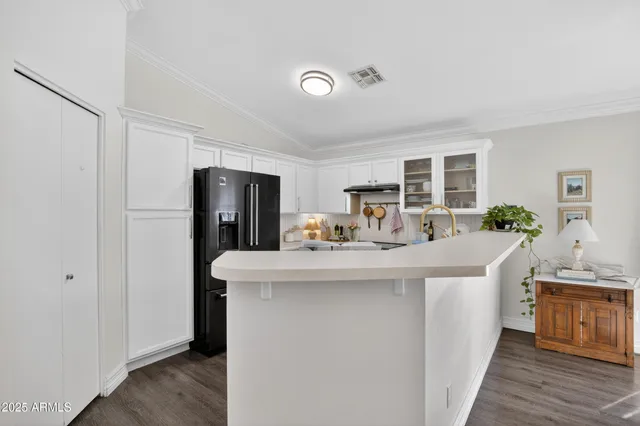 a kitchen with kitchen island a sink and a refrigerator