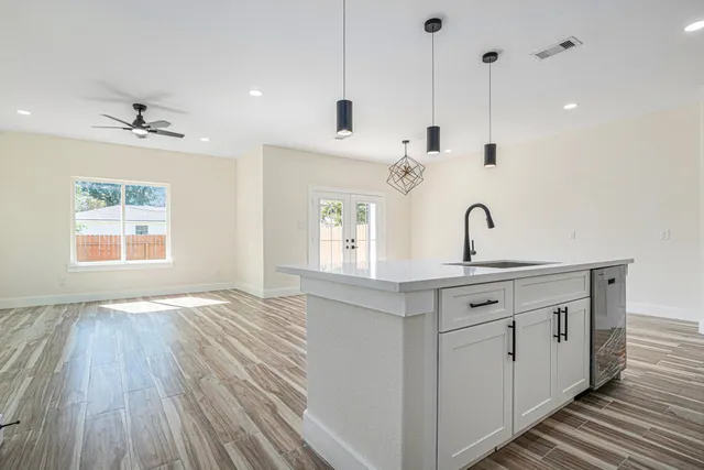 a view of a kitchen with wooden floor and windows