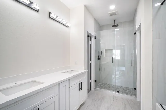 a bathroom with a sink shower and a mirror