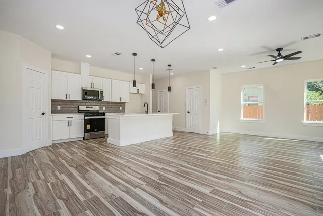 a view of kitchen with sink microwave and cabinets