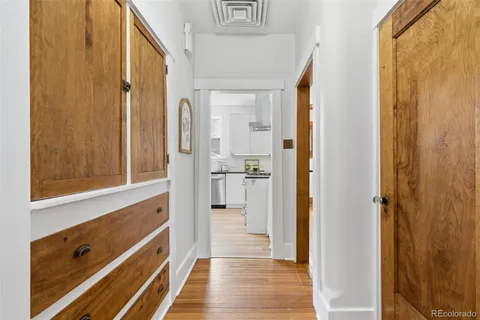 a view of a hallway with wooden floor and staircase