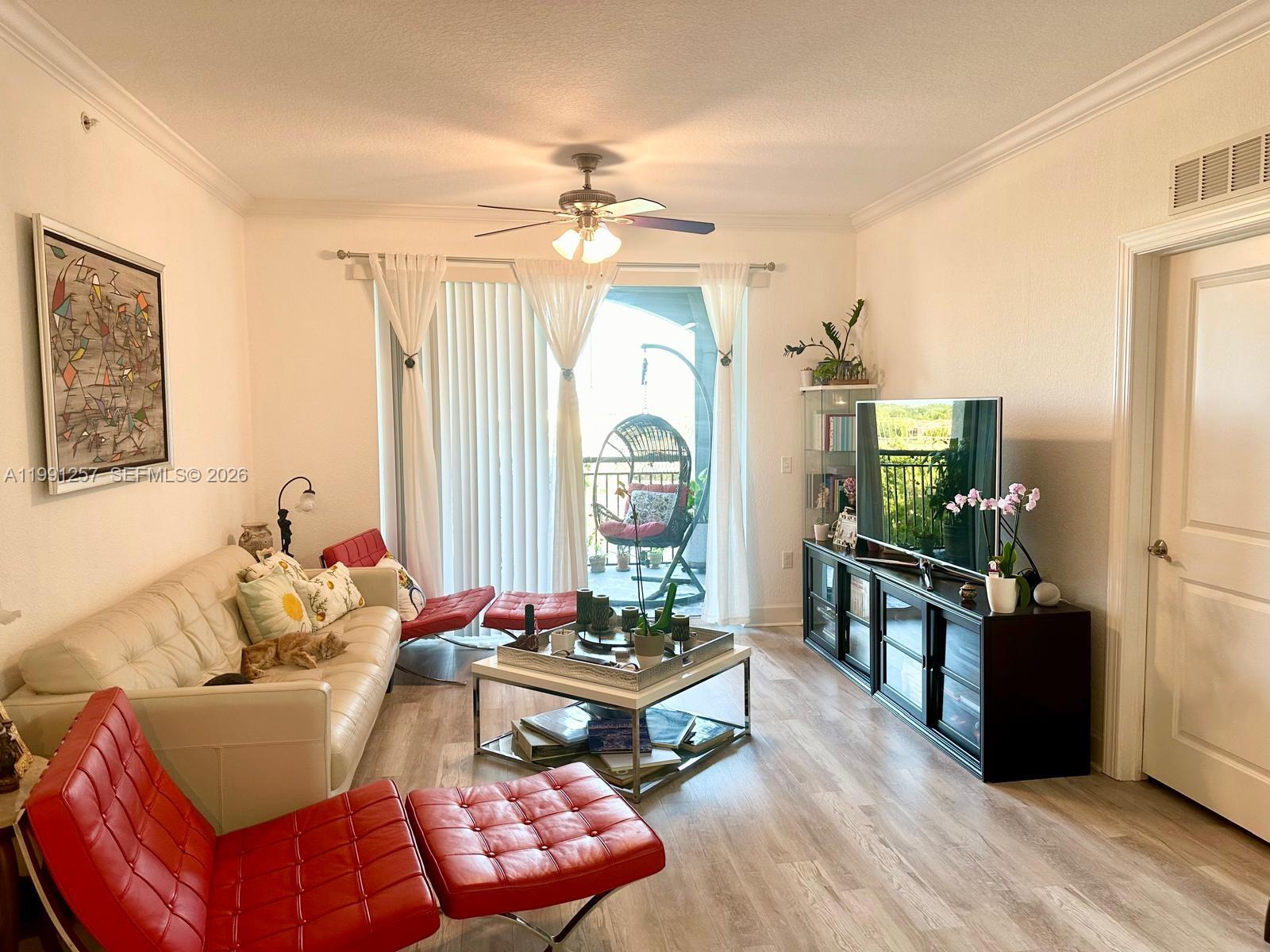 1660 Renaissance Commons Boulevard, Unit 2606 Boynton Beach, FL 33426 - Photo 13 of 26 a living room with furniture a large window and a chandelier