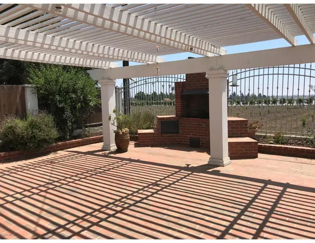 a view of a patio with table and chairs with wooden floor and fence