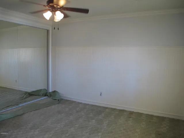 an empty room with a chandelier fan