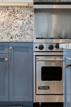 a large kitchen with kitchen island a large window a sink and stainless steel appliances