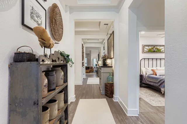 a living room with furniture kitchen view and a wooden floor