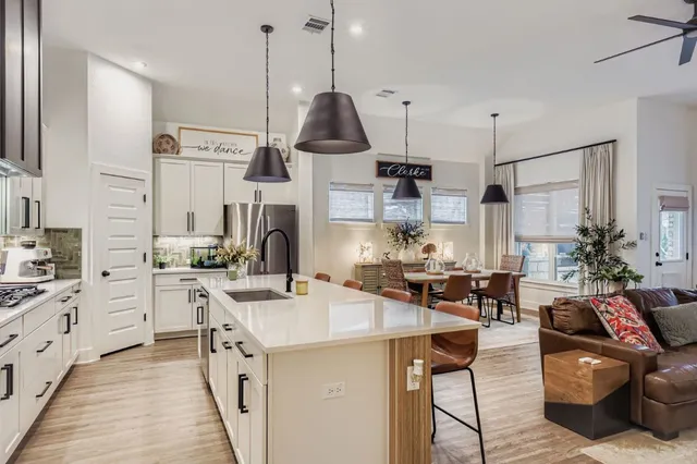 a kitchen with stainless steel appliances kitchen island granite countertop a sink a stove and a refrigerator