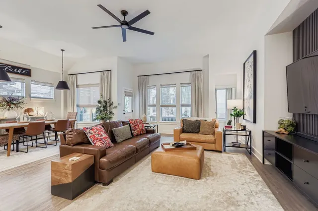 a living room with furniture kitchen view and a large window