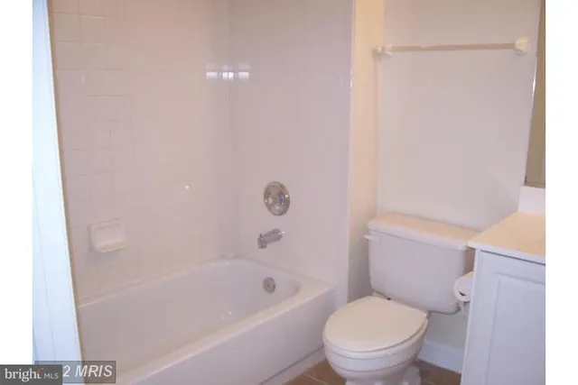 a white toilet sitting next to a bath tub