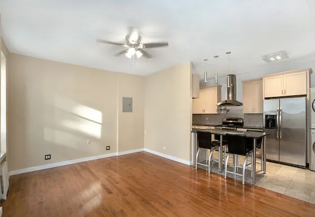 a kitchen with stainless steel appliances granite countertop a refrigerator a sink a stove and white cabinets