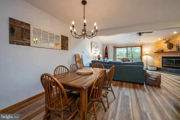 a view of a dining room with furniture a chandelier and wooden floor