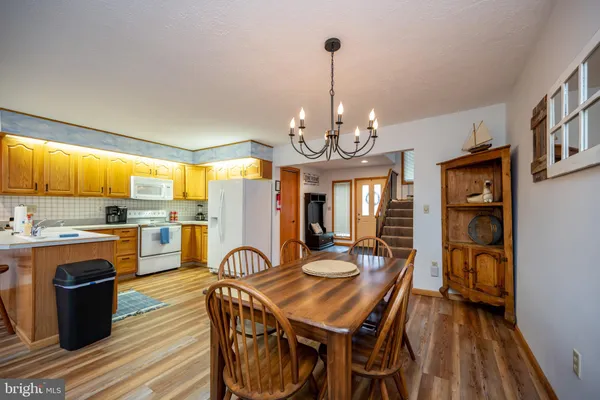 a dining room with furniture a chandelier and wooden floor