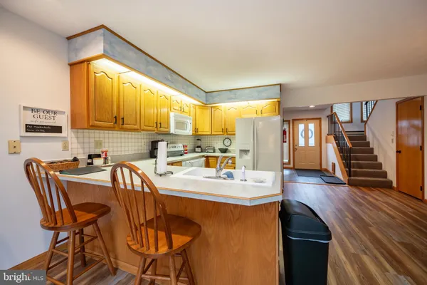 a kitchen with a table chairs stove and wooden floor