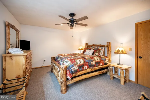 a bedroom with a bed and flat tv screen on the dresser