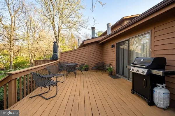 a balcony with wooden floor and outdoor seating