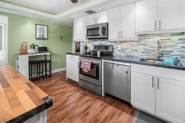 a kitchen with stainless steel appliances granite countertop wooden cabinets a stove top oven a sink and dishwasher