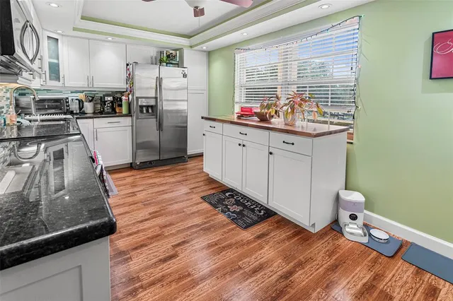a kitchen with stainless steel appliances kitchen island granite countertop a refrigerator and a stove