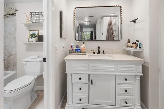 a bathroom with a sink vanity mirror and toilet