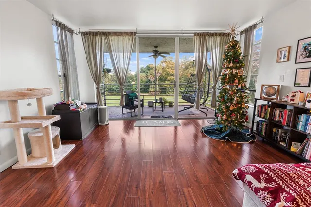 a living room with furniture large window and wooden floor