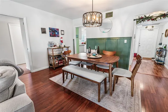 a view of a dining room with furniture a chandelier and wooden floor