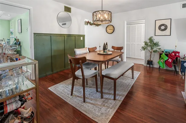 a view of a dining room with furniture a chandelier and wooden floor