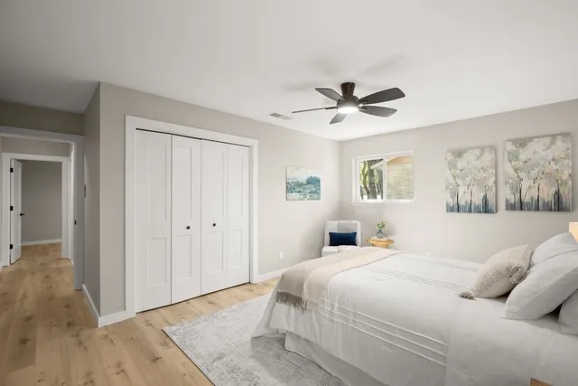 a bedroom with a large bed and a ceiling fan