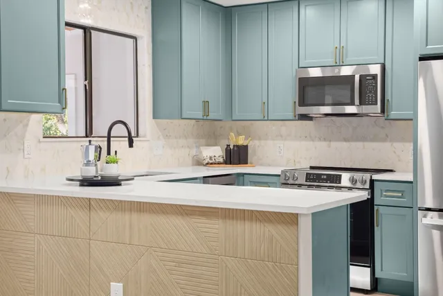 a kitchen with stainless steel appliances granite countertop a sink stove and microwave