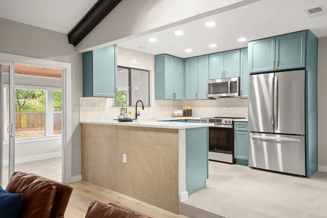 a kitchen with kitchen island white cabinets and refrigerator